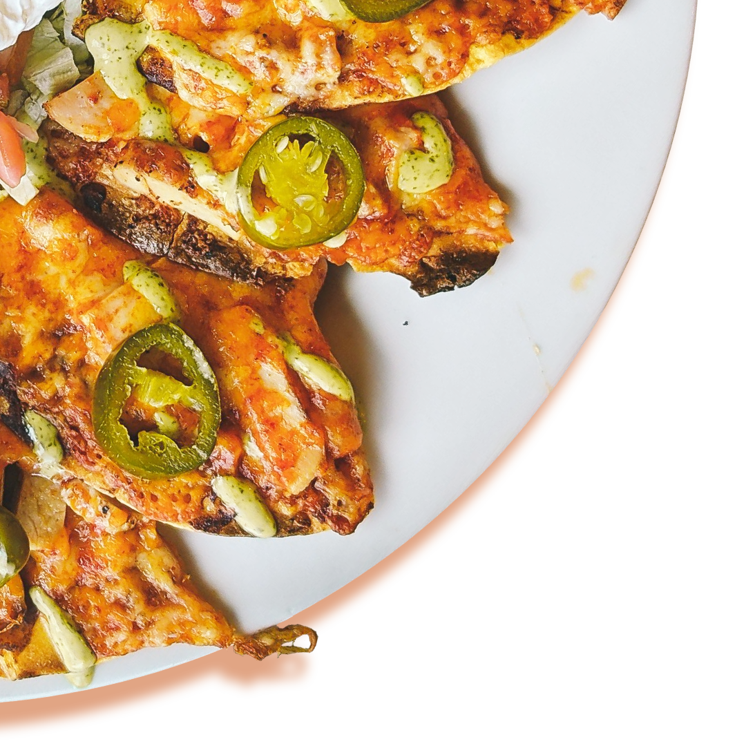 Pizza slices with jalapeños and a creamy drizzle on a white plate.