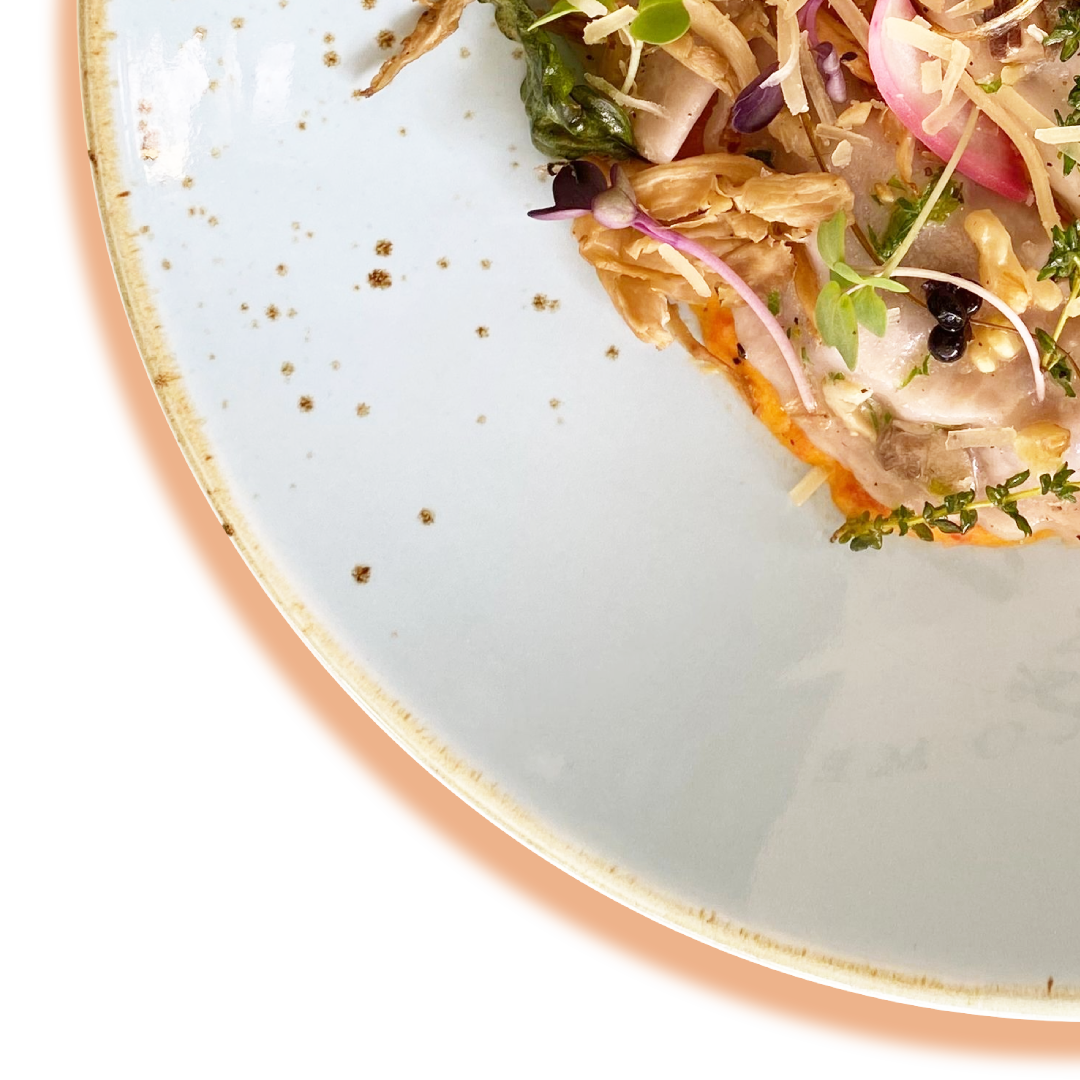 Gourmet salad with greens, red onions, and toppings on a white plate.